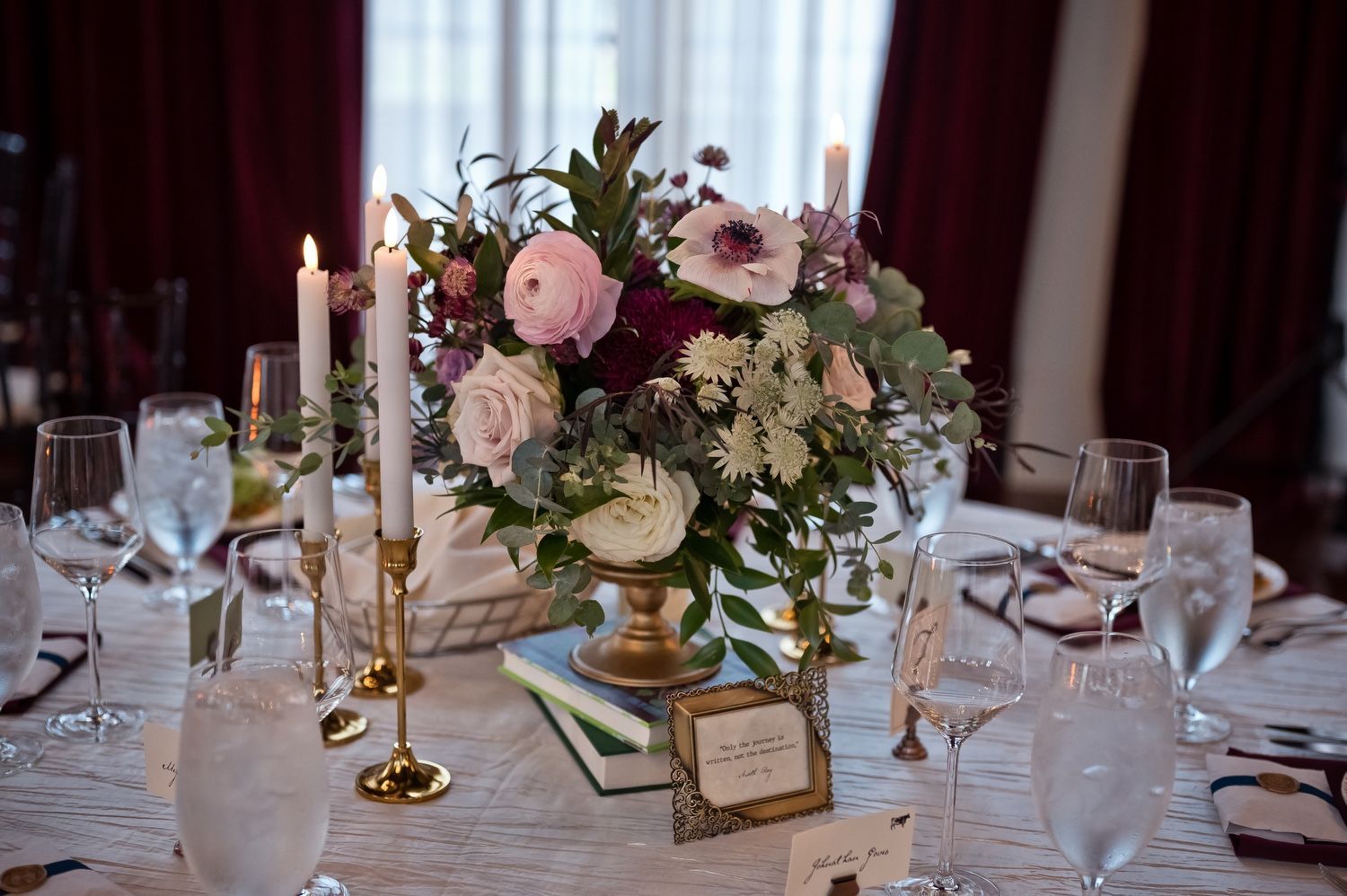 A table with a vase of flowers and candles on it.