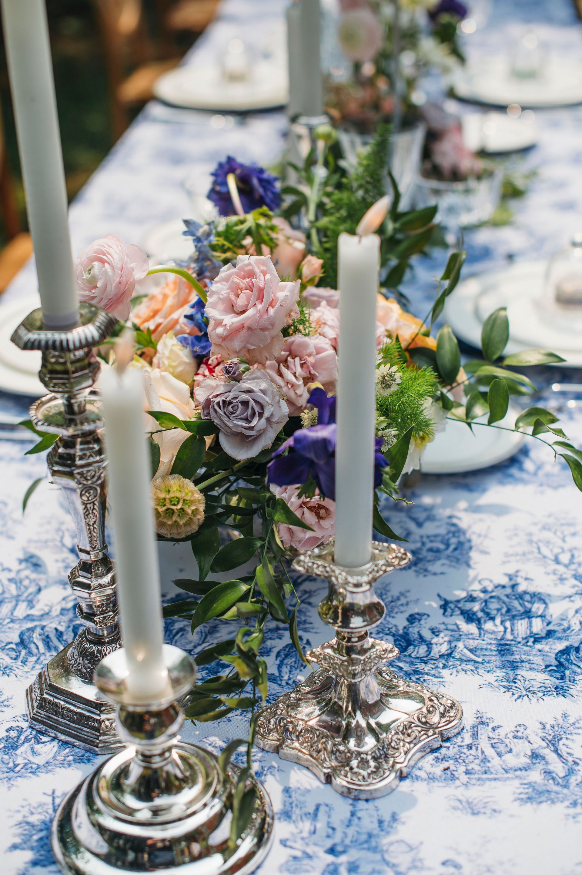 A table with candles and flowers on it.