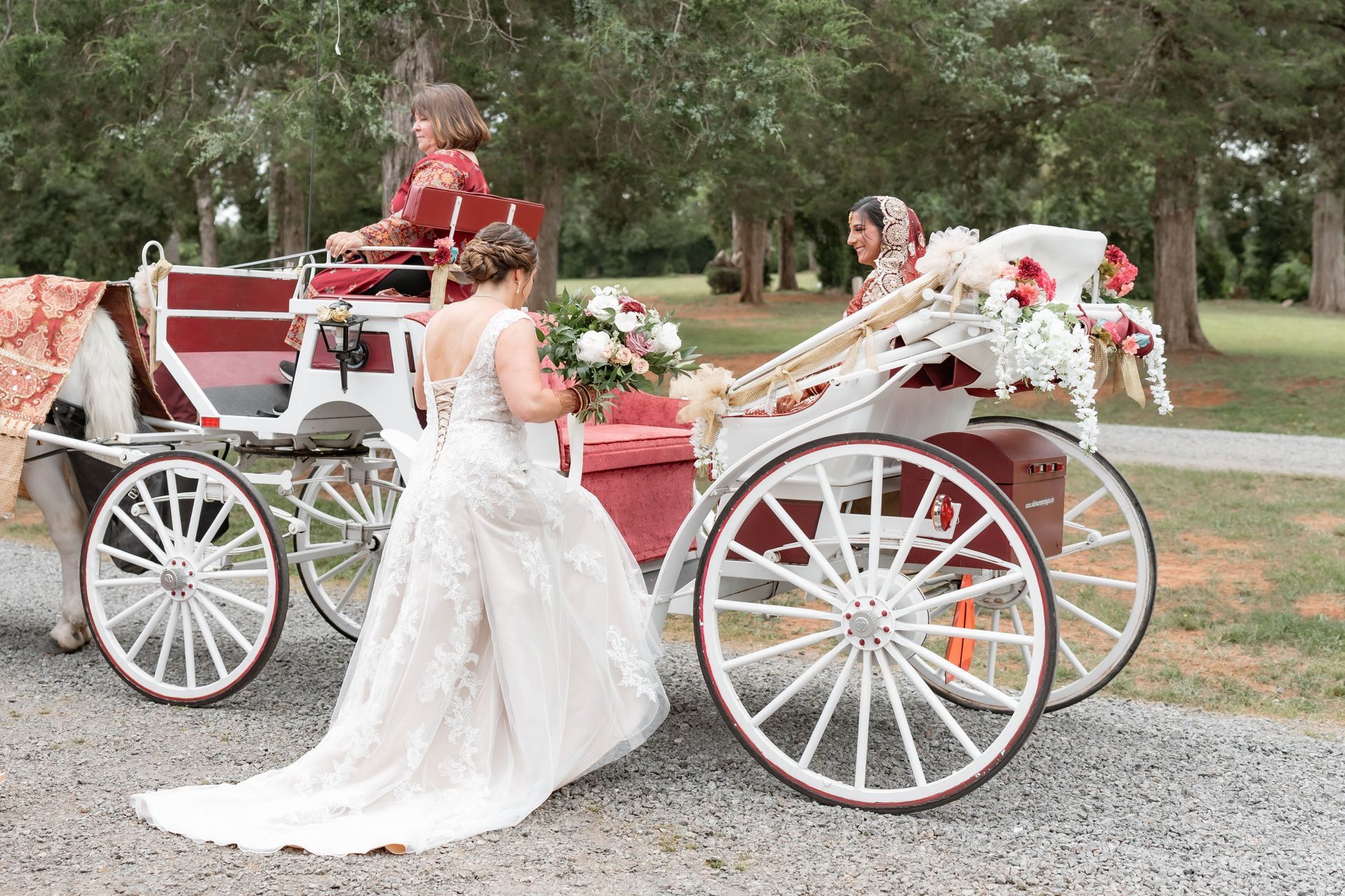 A bride in a wedding dress is walking towards a horse drawn carriage.