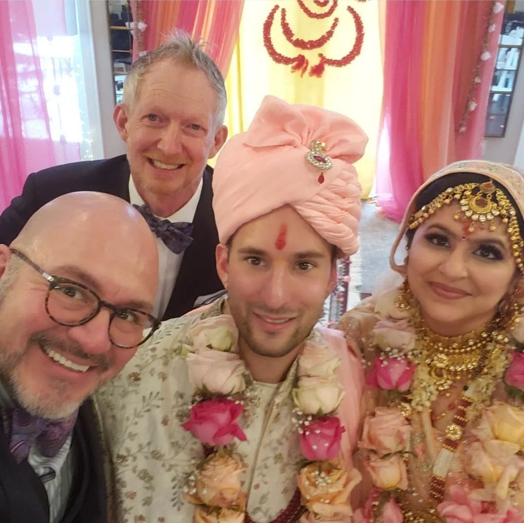 A group of people posing for a picture including a bride and groom
