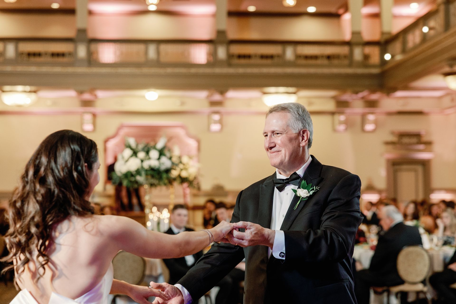 A bride is dancing with her father at her wedding reception.