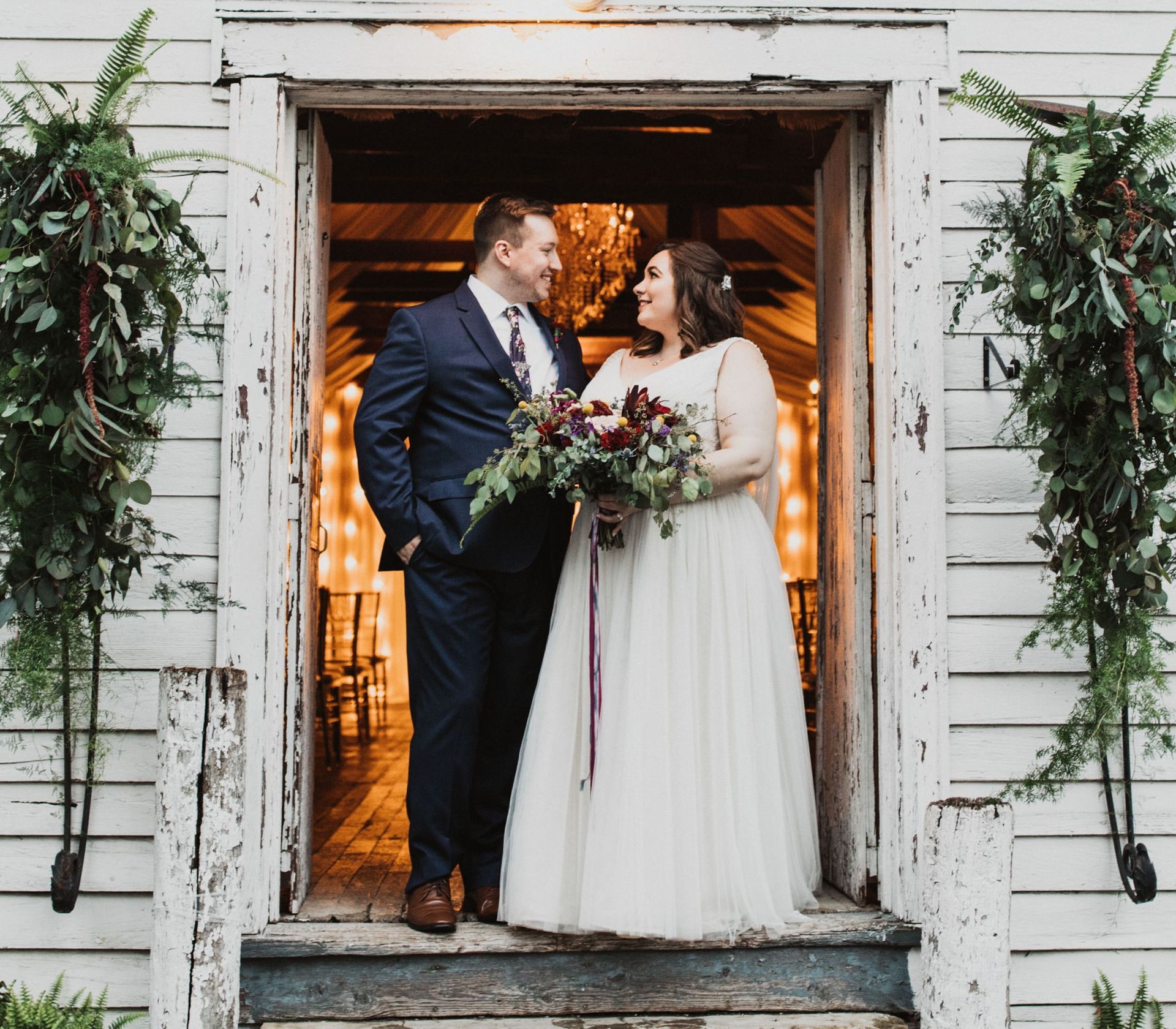 A bride and groom are standing in the doorway of a building.