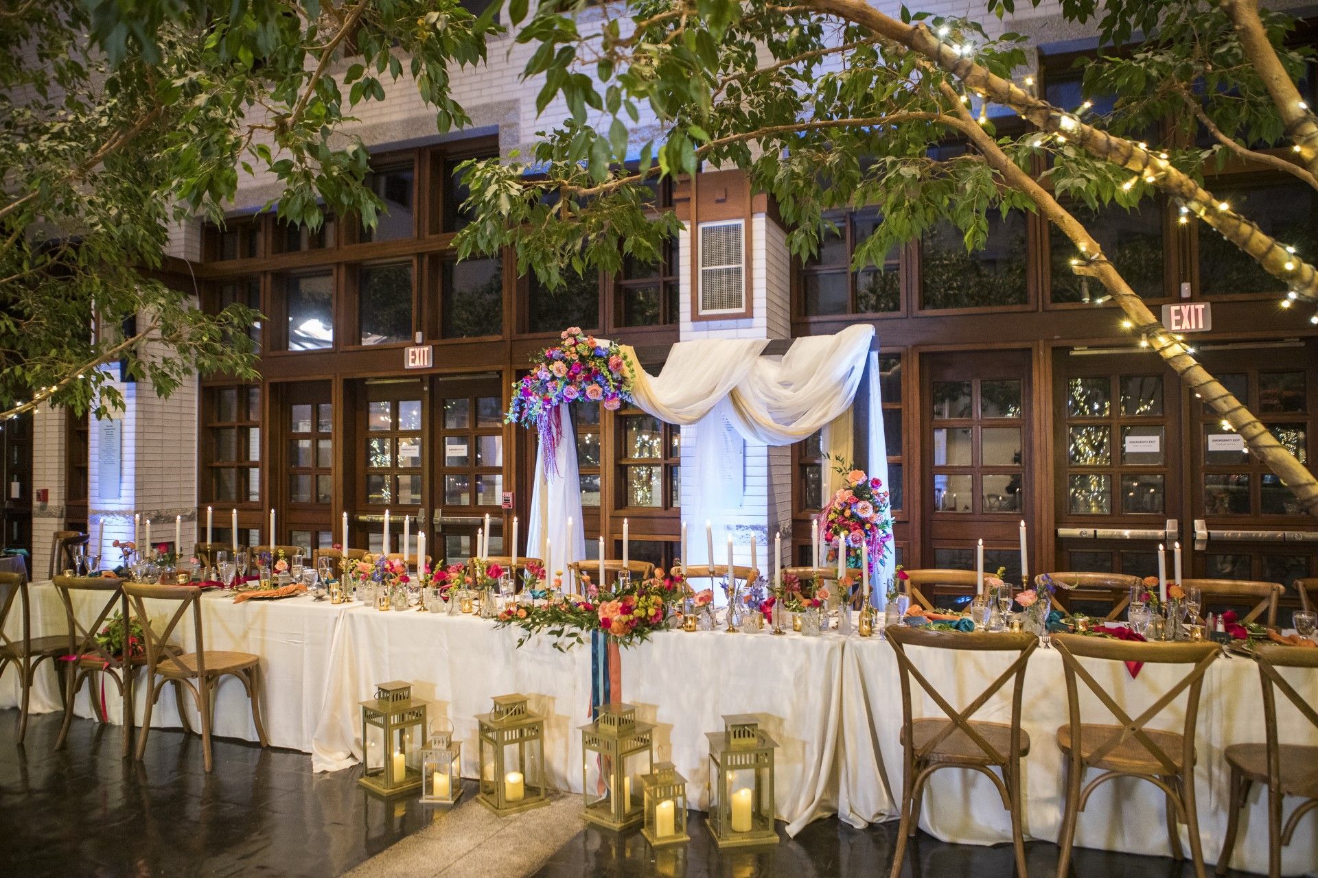 A long table with candles and flowers on it in a room.