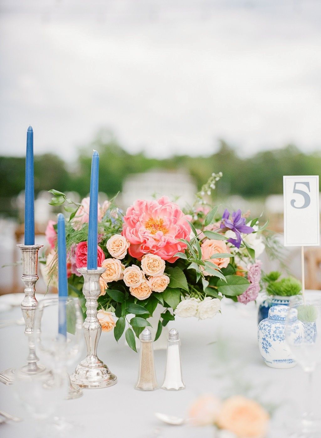 A table with a vase of flowers and candles on it.