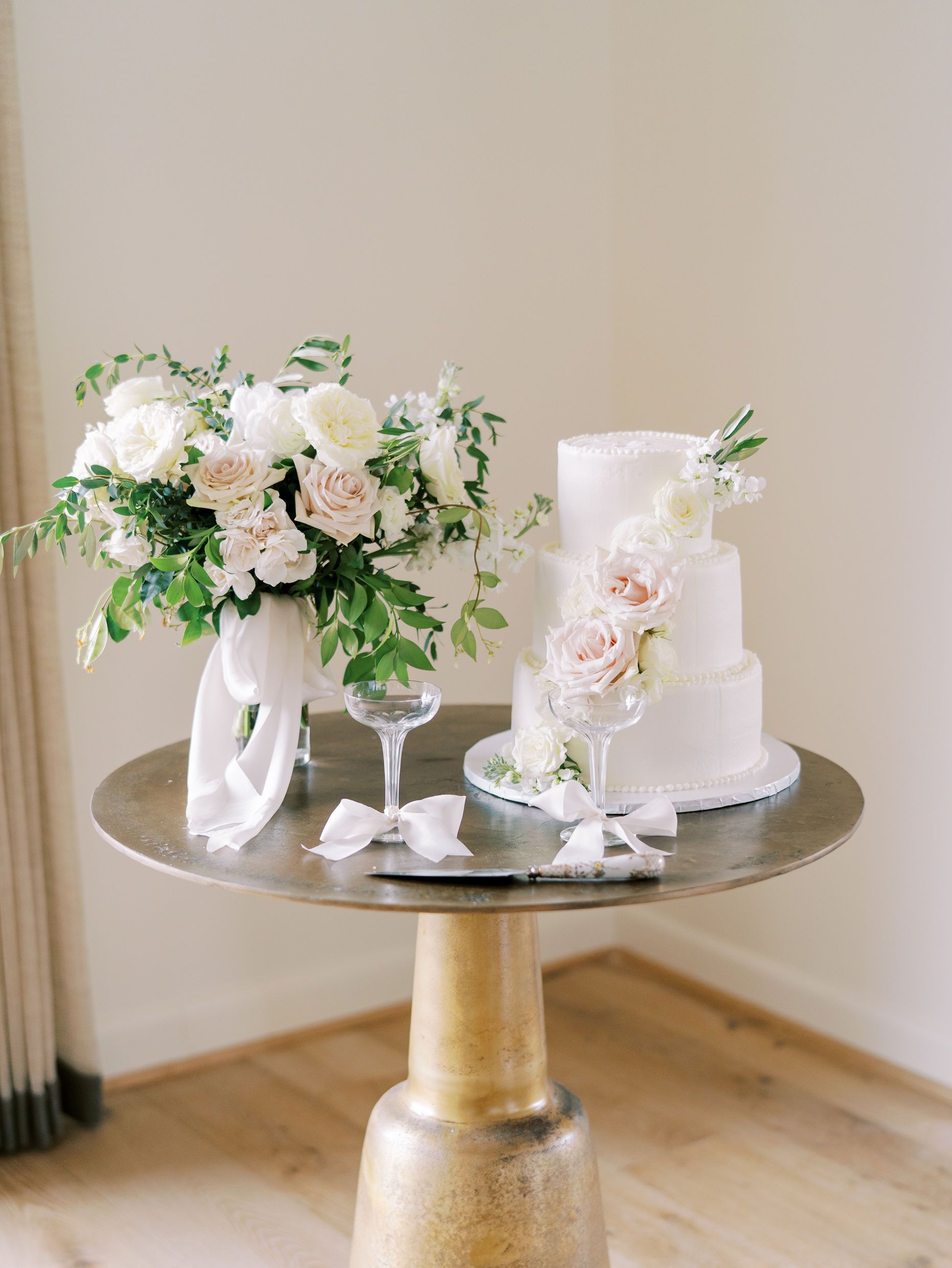 A table with two cakes and a vase of flowers on it.