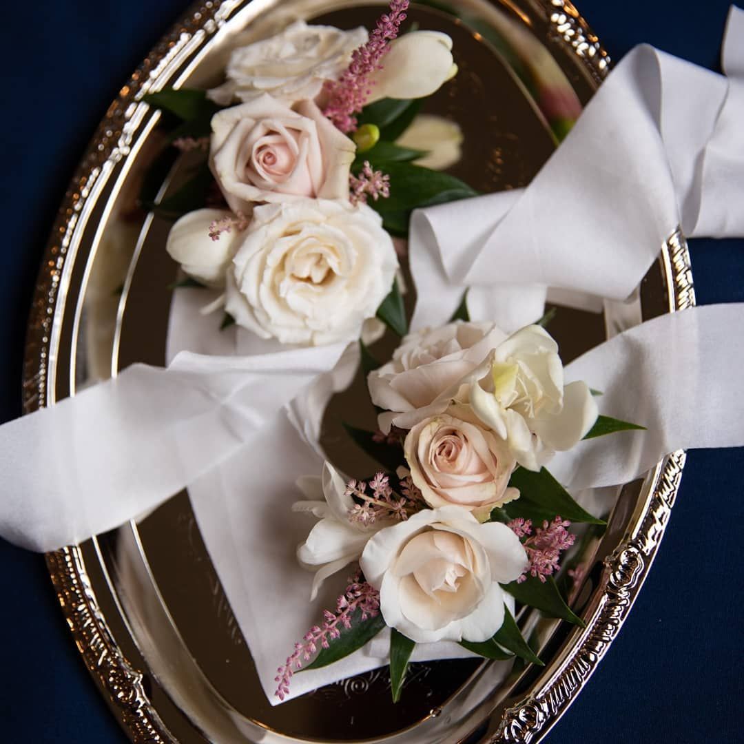 A silver tray with flowers and ribbon on it