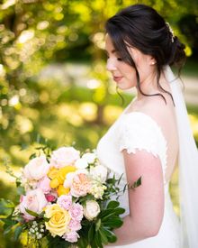 A bride in a white dress is holding a bouquet of flowers.