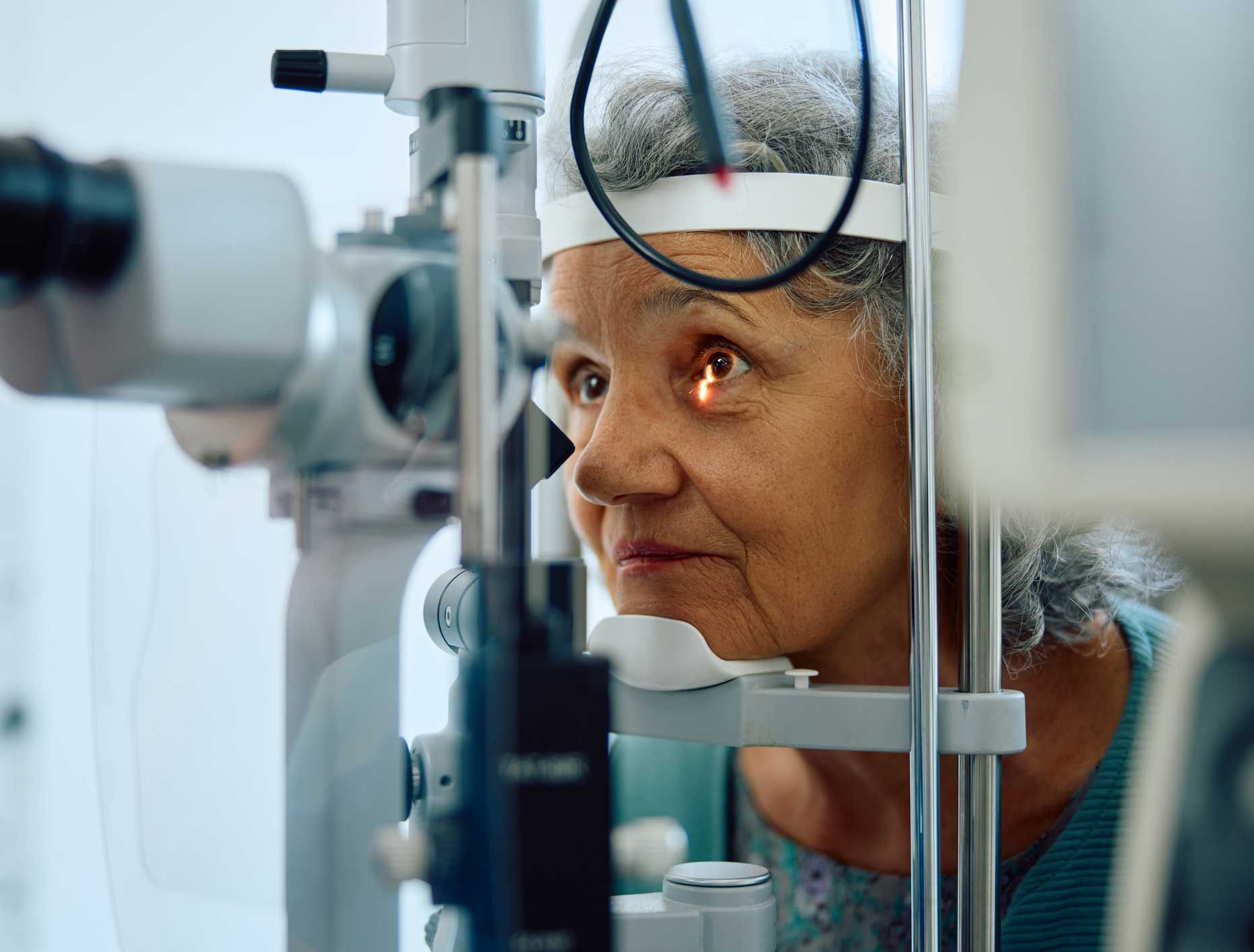 Woman having an eye exam with a slit lamp in a medical office.