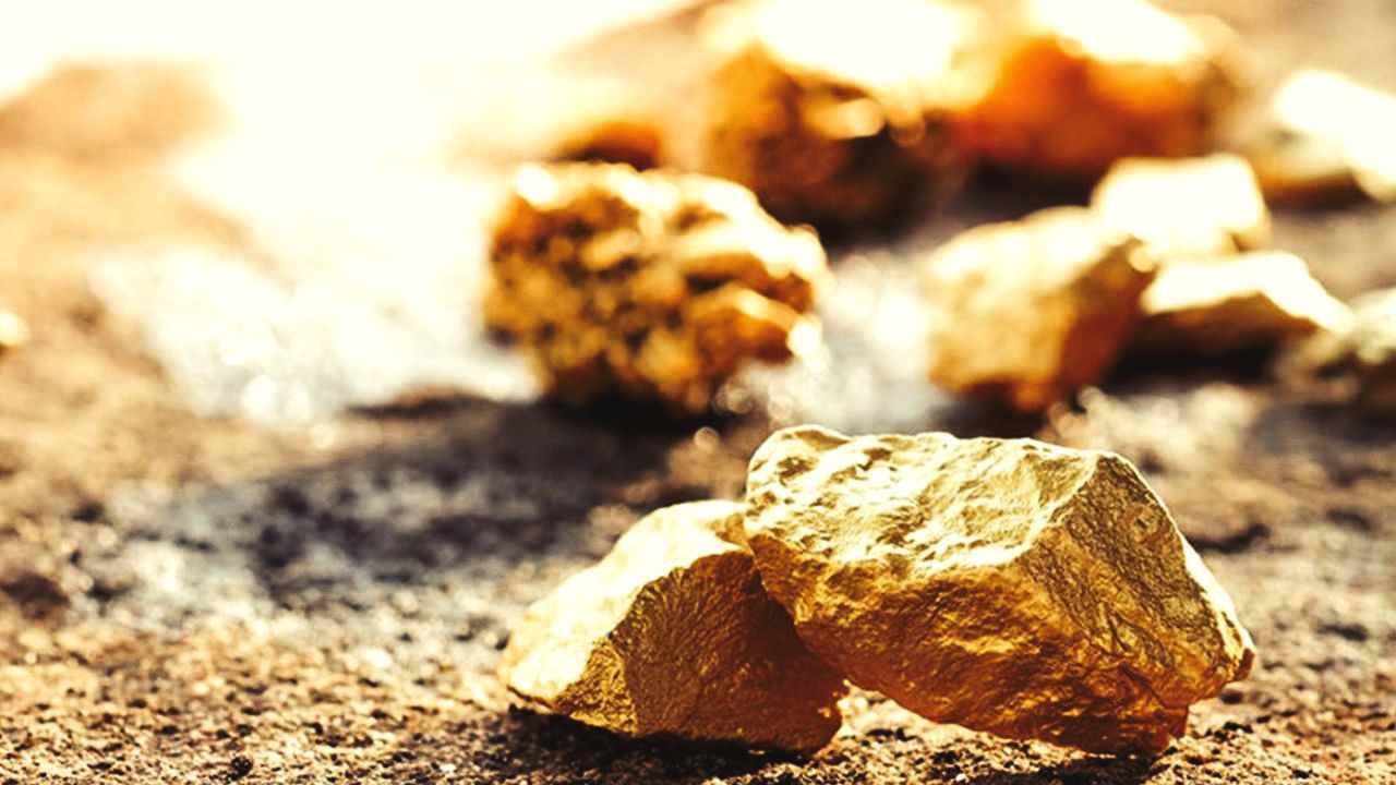 Un montón de pepitas de oro encima de un montón de tierra.