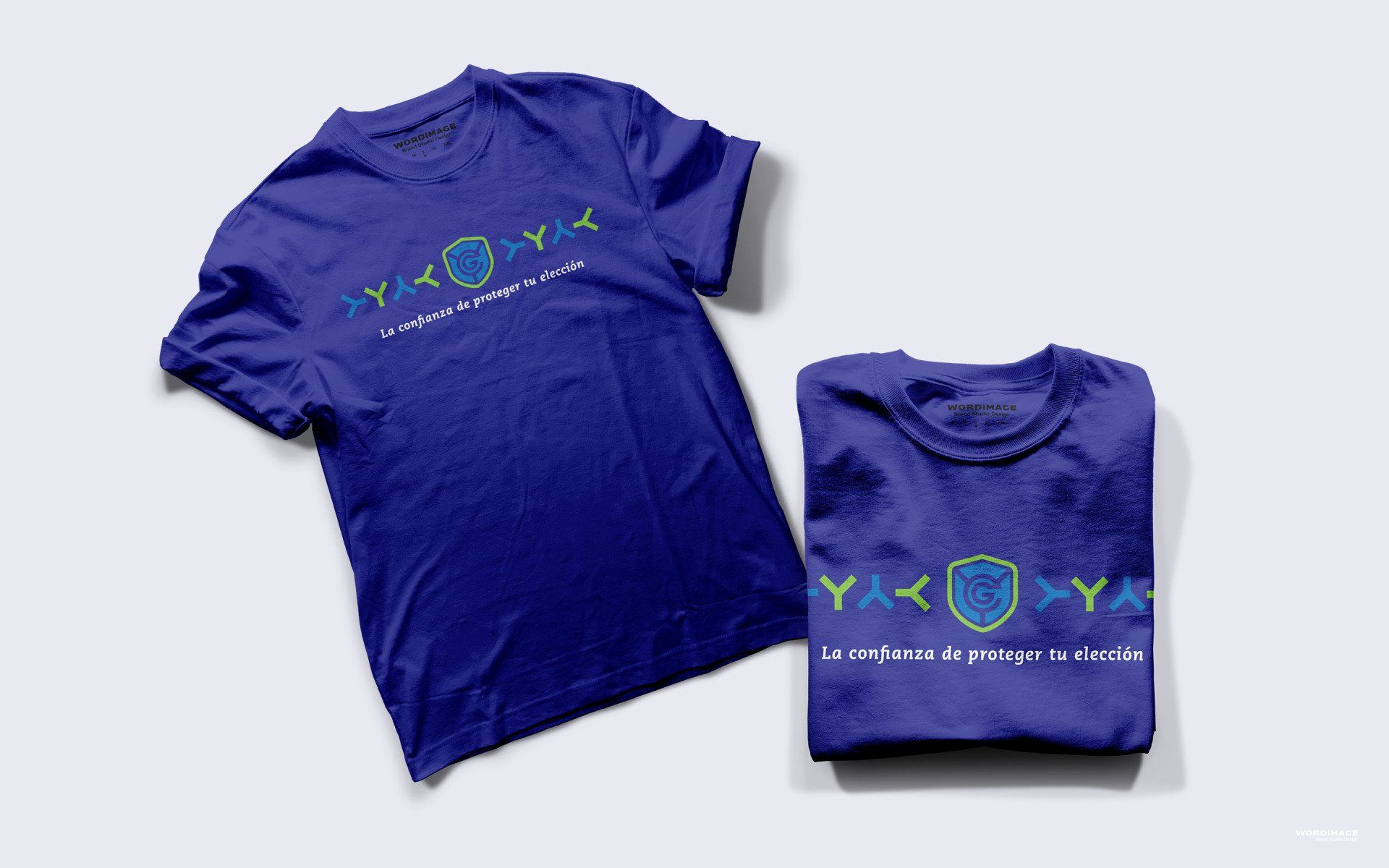 A blue t-shirt is sitting on top of a white table next to a folded t-shirt.