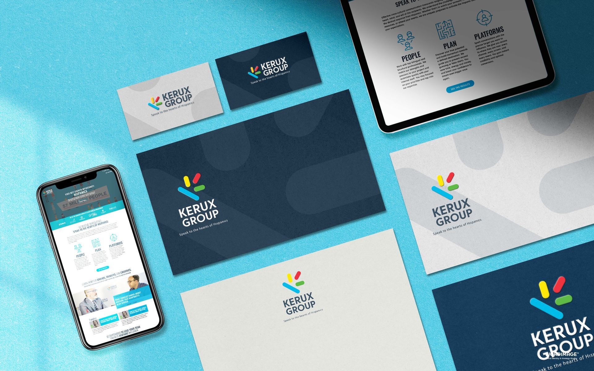 A phone , tablet , envelope , and business card are sitting on a blue table.