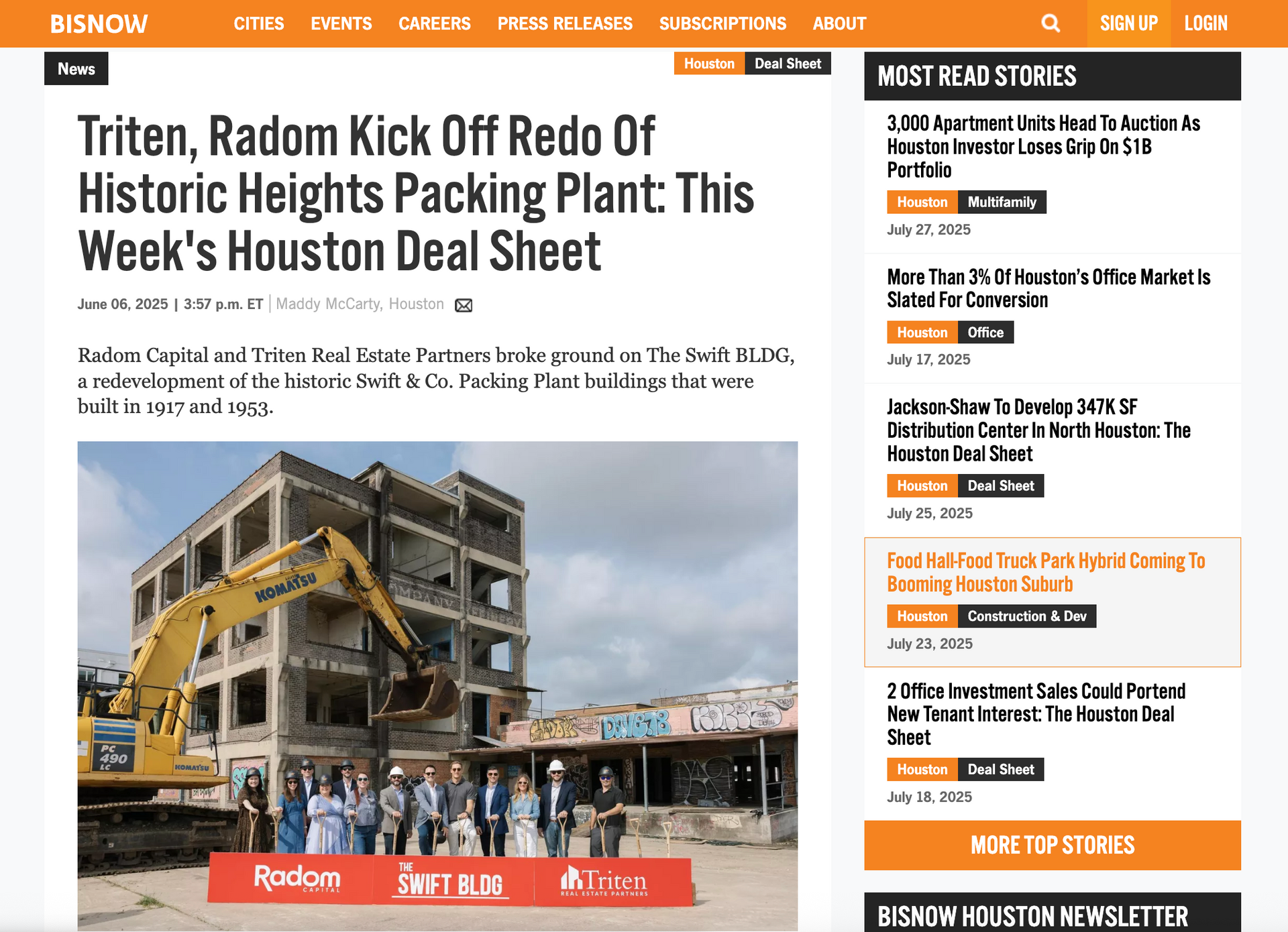 News article about the redo of a historic packing plant. Group of people with machinery and the building.