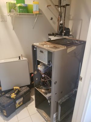 A room with a furnace and a toolbox in it.