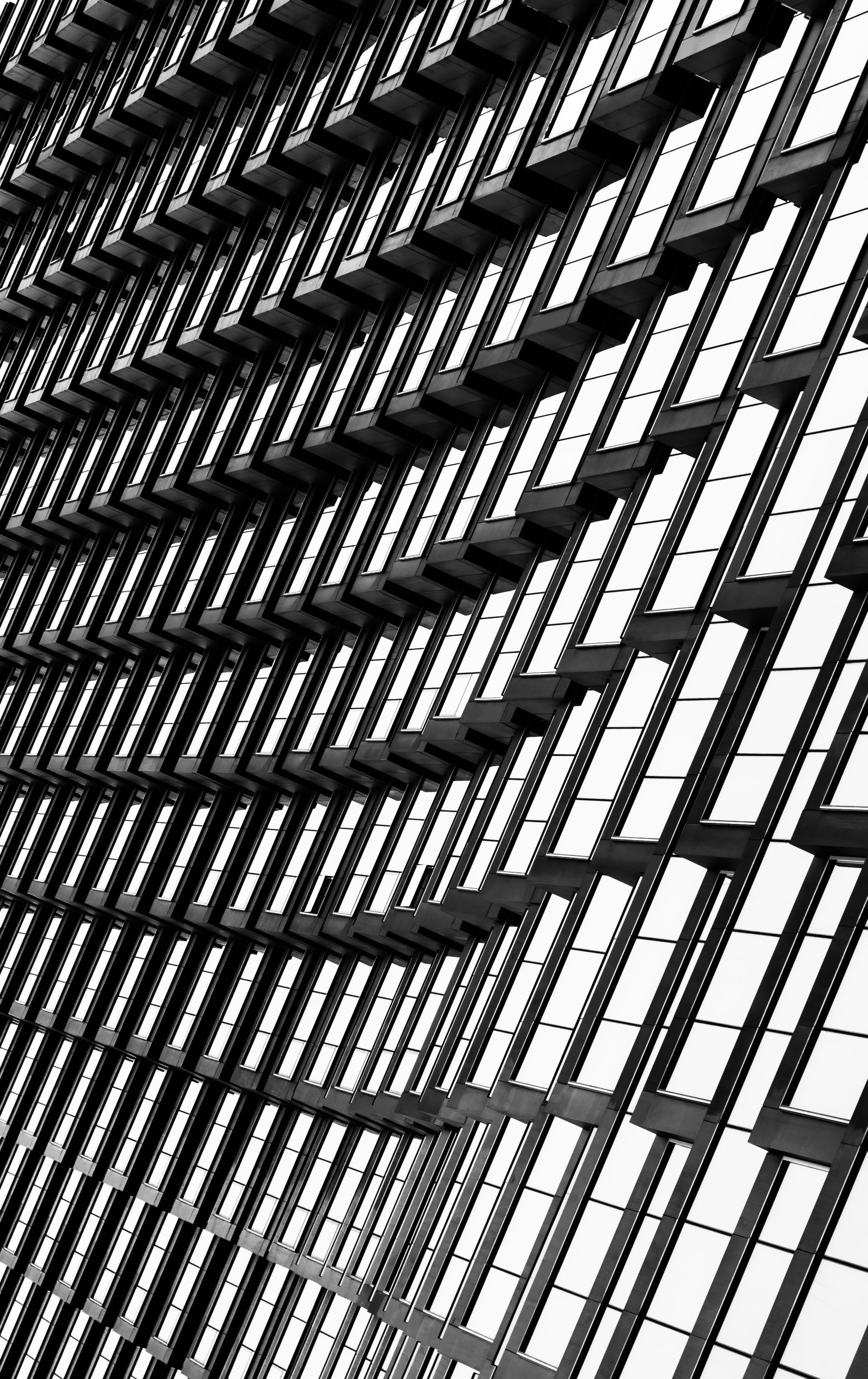 Abstract black and white architectural detail of a building facade, with repeating rectangular patterns creating a layered effect.