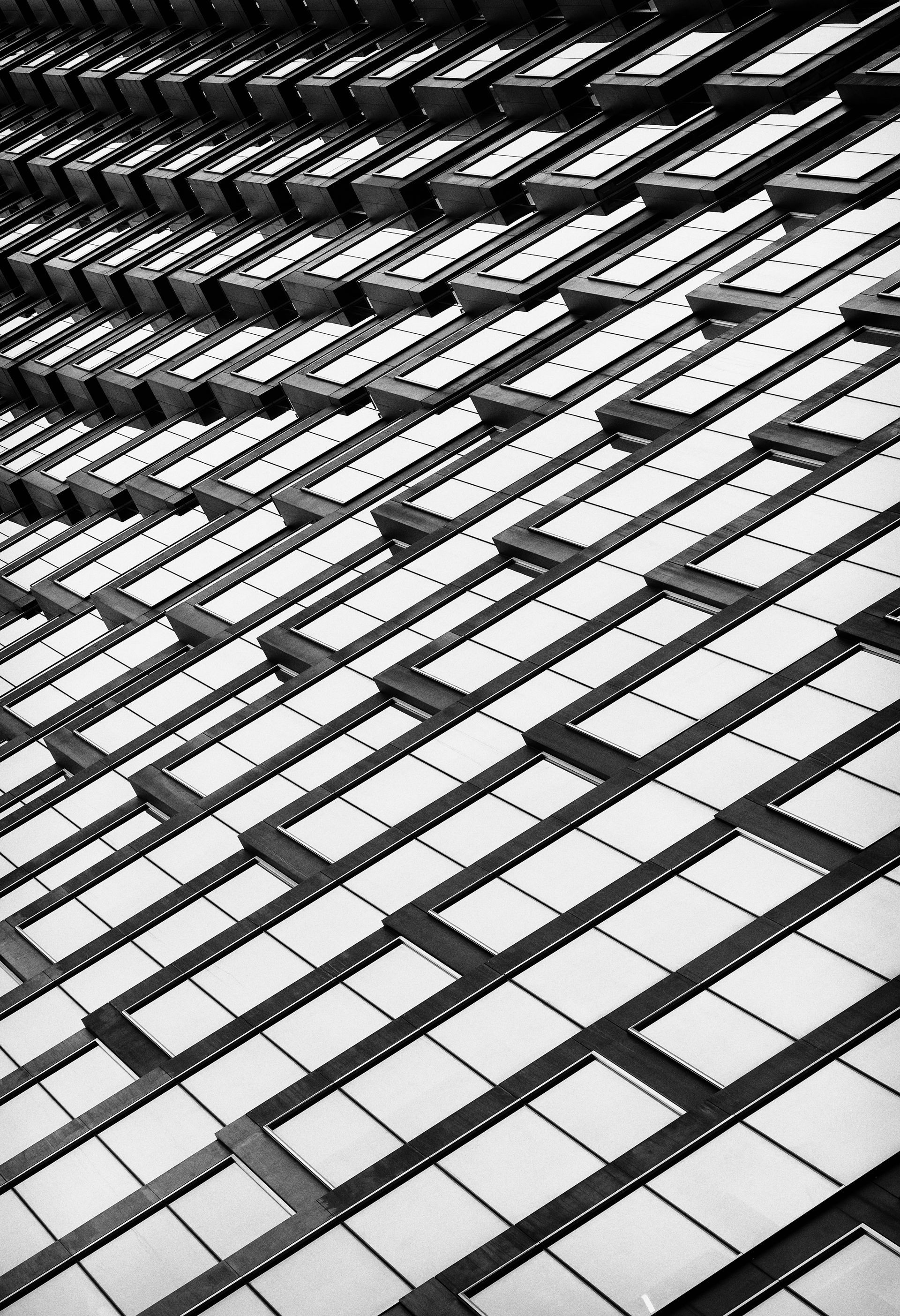 Rows of stadium seats, black and white, angled perspective.