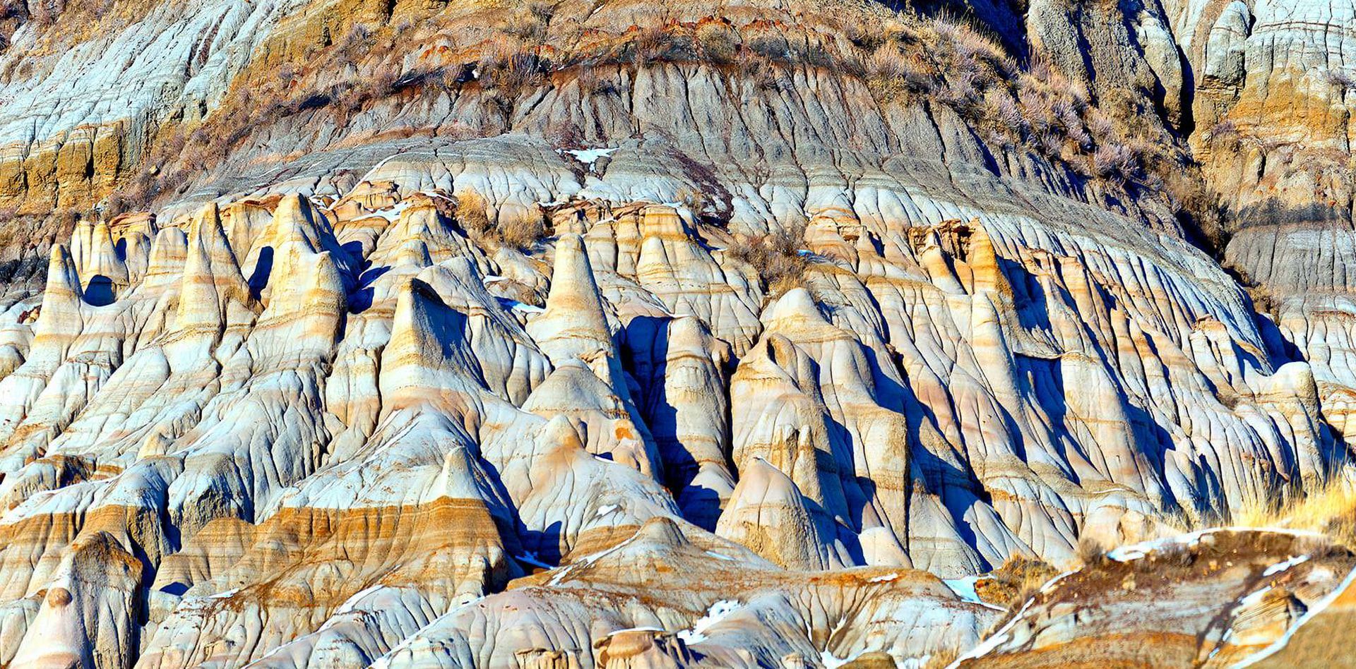 Layered rock formations in various colors, showcasing natural erosion and geological history.
