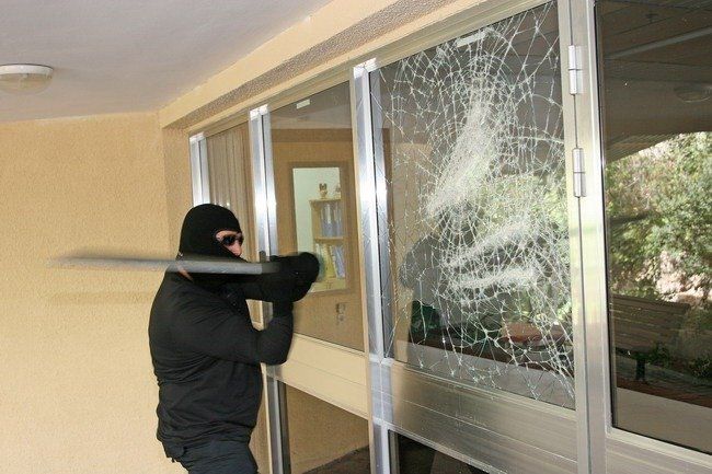 Burglar Smashing Glass Window — Premium Window Films in South Lismore, NSW