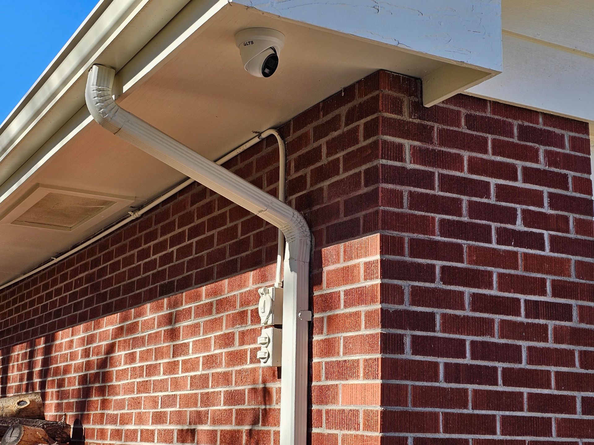 Metal walk-in refrigerator/freezer in a commercial setting; door has handles and latch; control box on the wall.