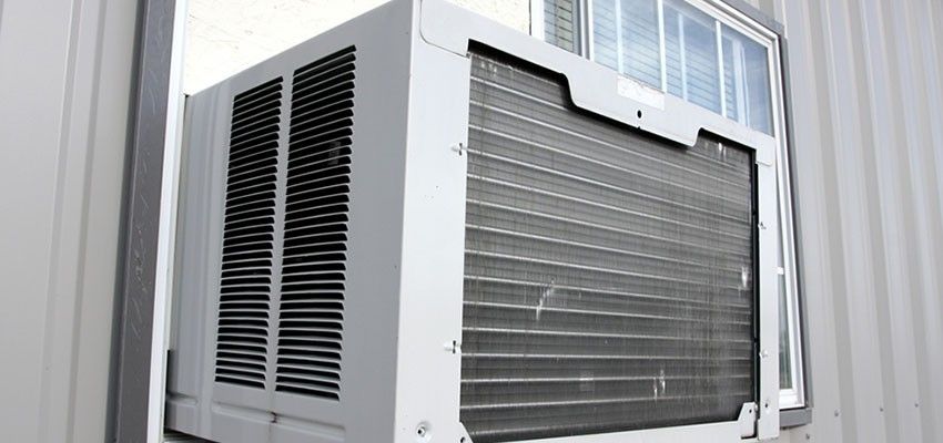 A window air conditioner is mounted on the side of a building.