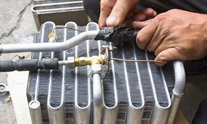 A man is working on a car air conditioner.