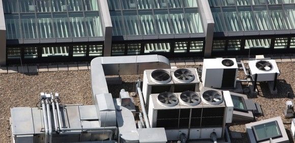 An aerial view of a building with a lot of air conditioning equipment on the roof