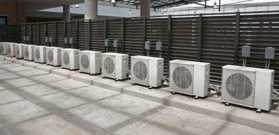 A row of air conditioners are lined up in a row.