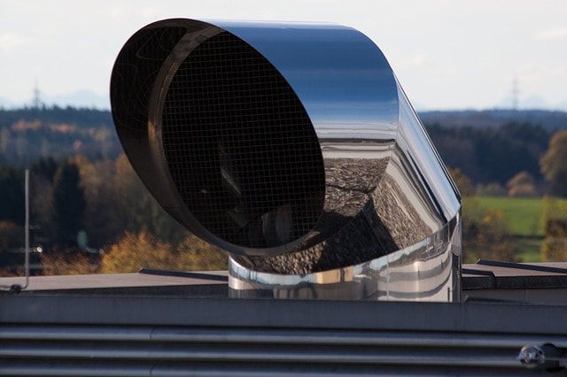 A stainless steel pipe is sitting on top of a building