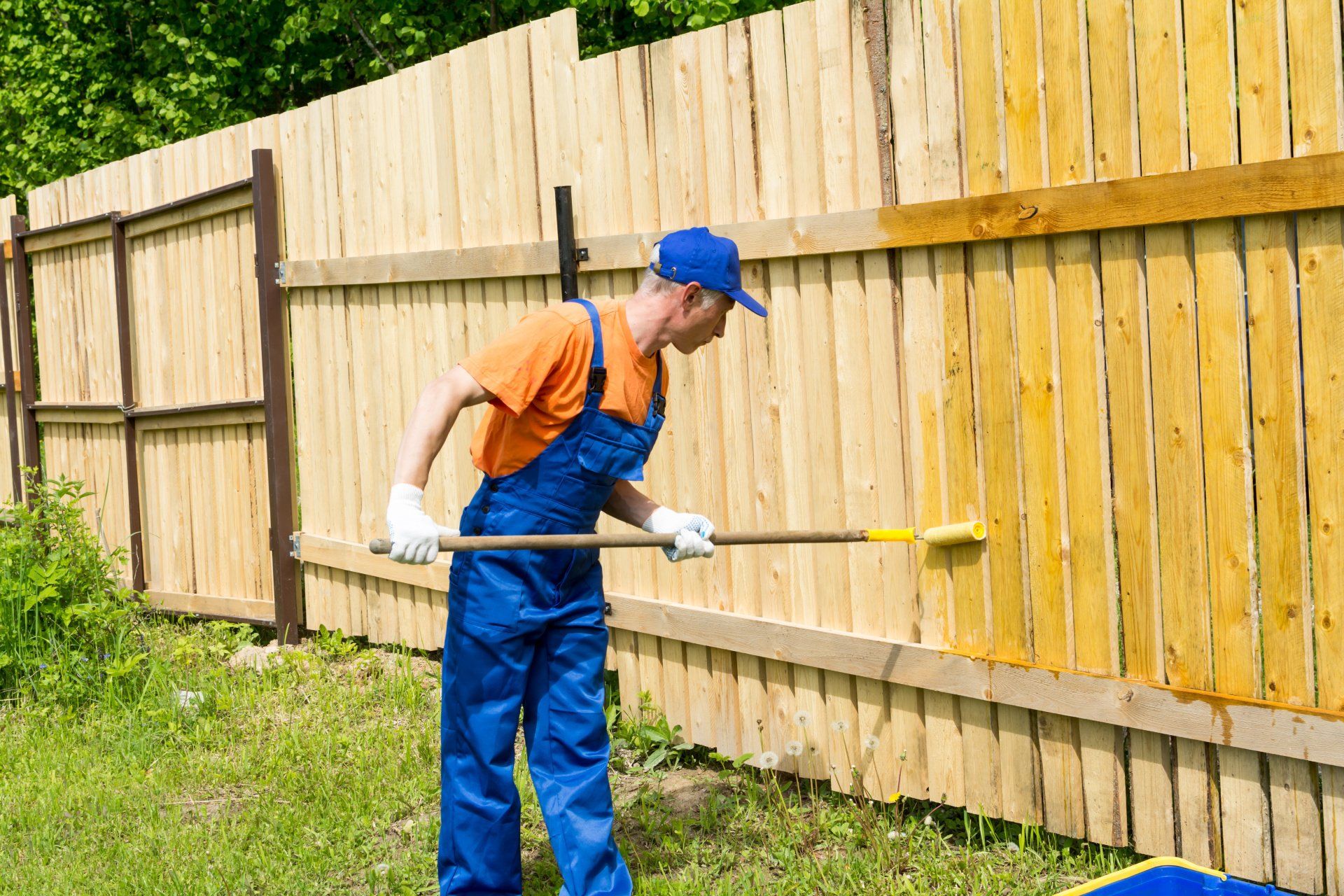 Staining a fence with a roller
