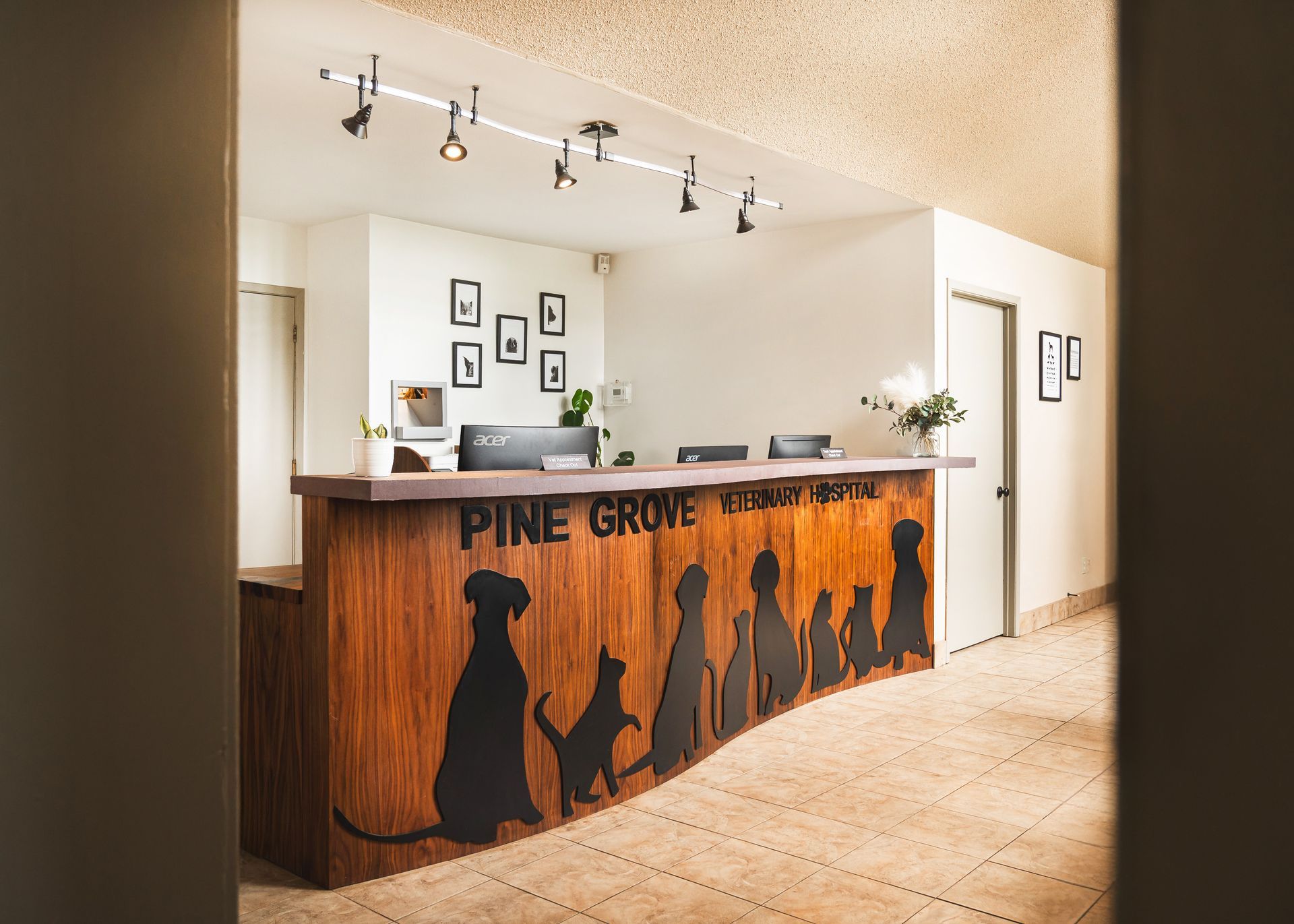 A wooden reception desk with silhouettes of dogs on it.