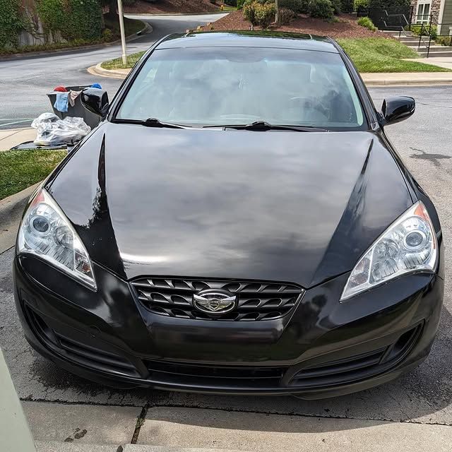 A black car is parked on the side of the road