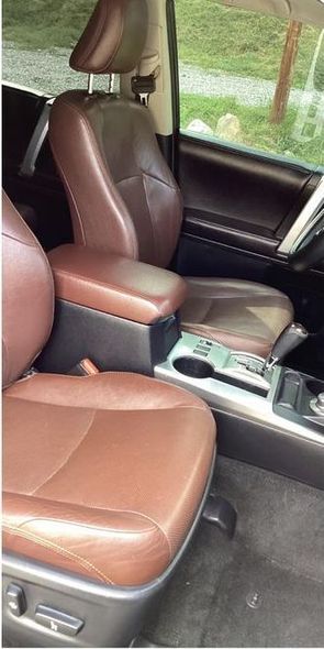 The interior of a car with brown leather seats and a center console.