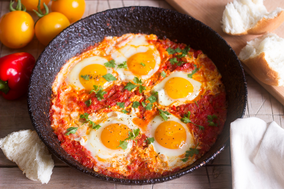 A pan filled with eggs and tomato sauce on a table.