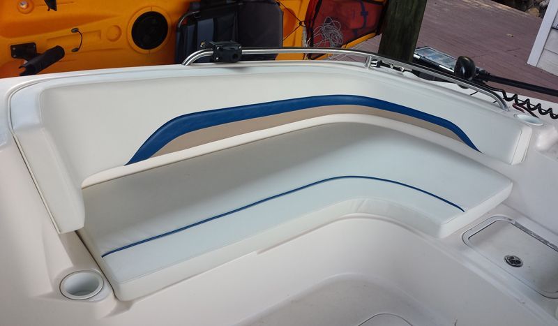 Boat interior with white seating and blue/tan accents.