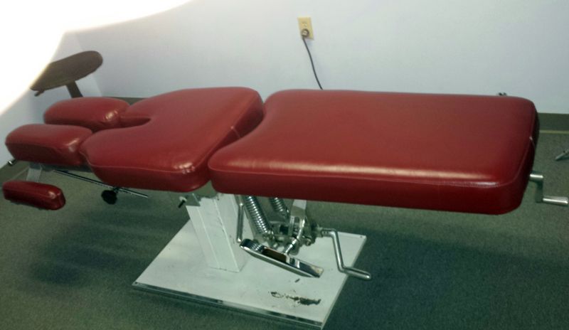 Red chiropractic table in a medical office setting.