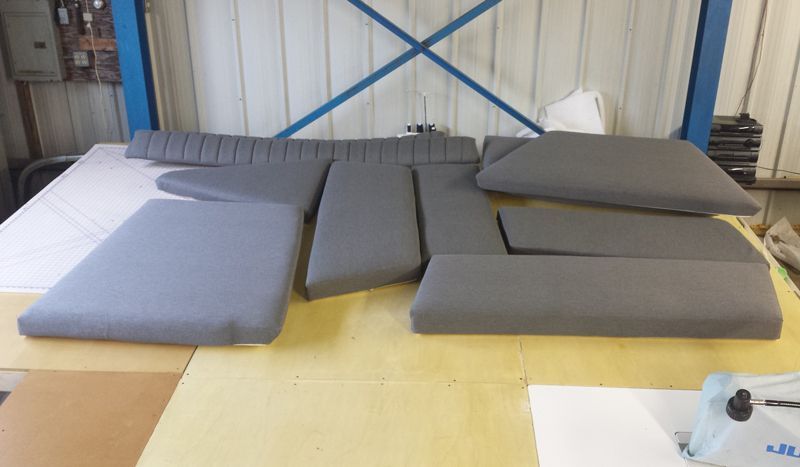 Gray upholstered foam pieces on a workbench in a workshop.
