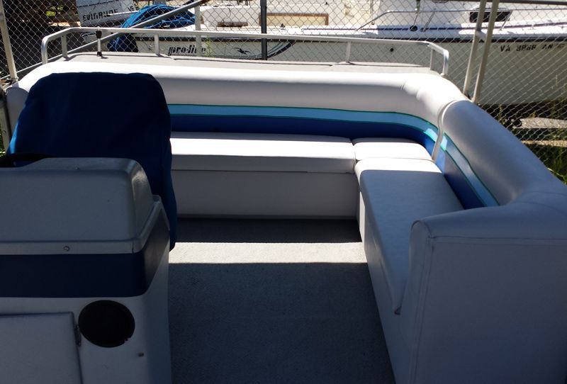 A white pontoon boat interior with blue and white seating.