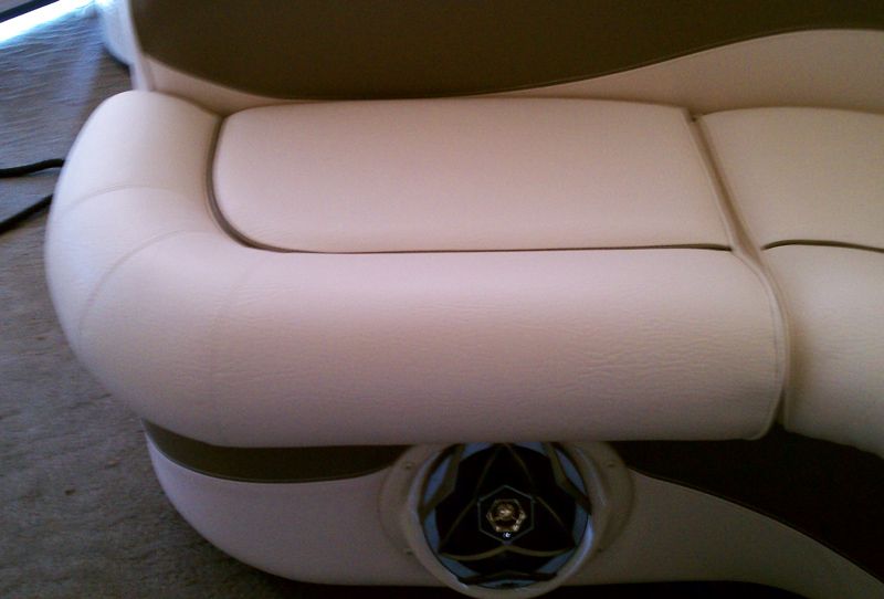 Cream and brown leather sofa with a rounded armrest, featuring a cup holder.