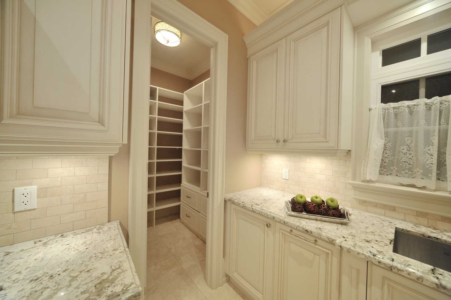 A kitchen with white cabinets and granite counter tops