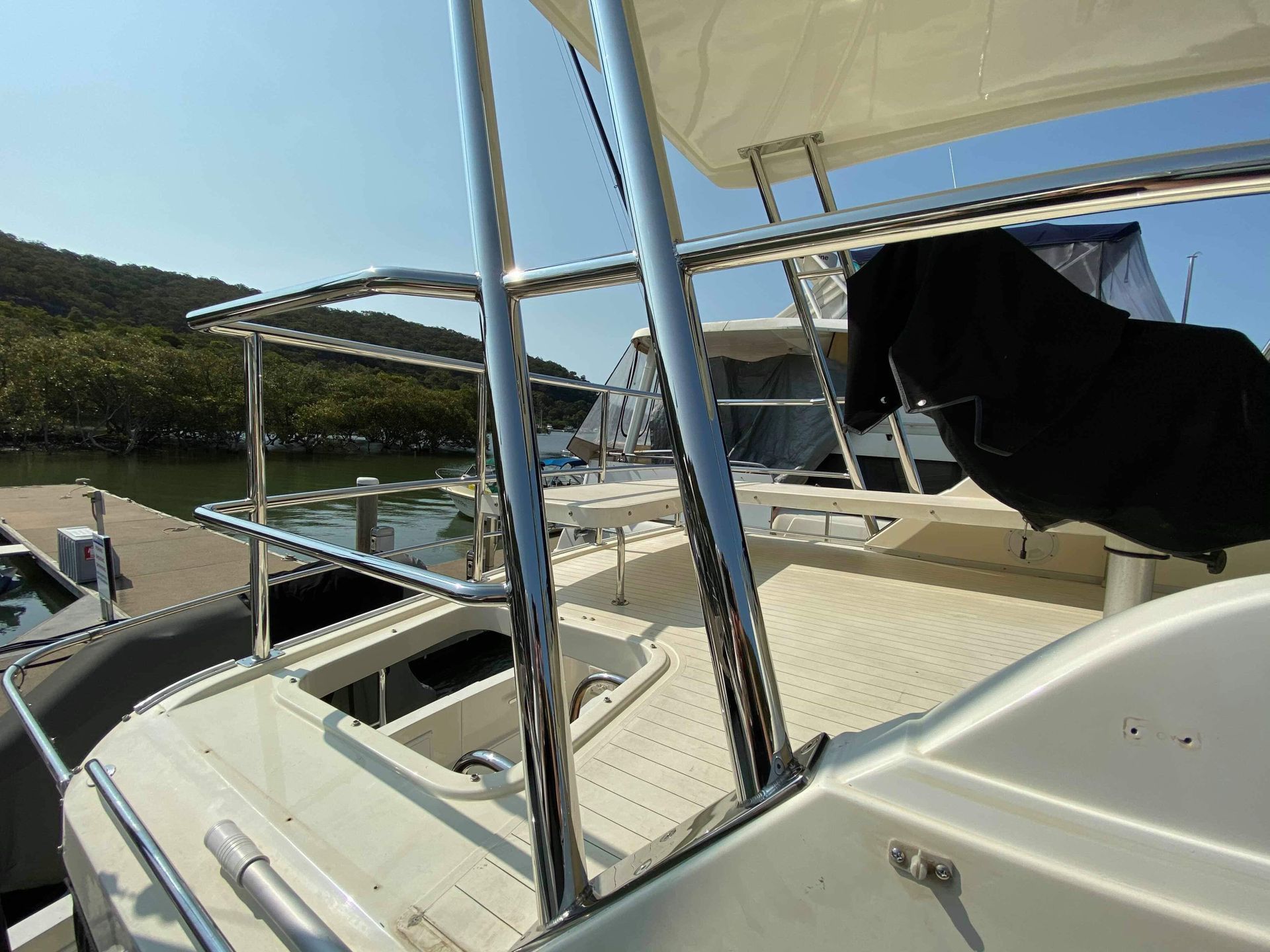 A Boat is Docked at a Dock With Mountains in the Background — EB Metalworks in Somersby, NSW
