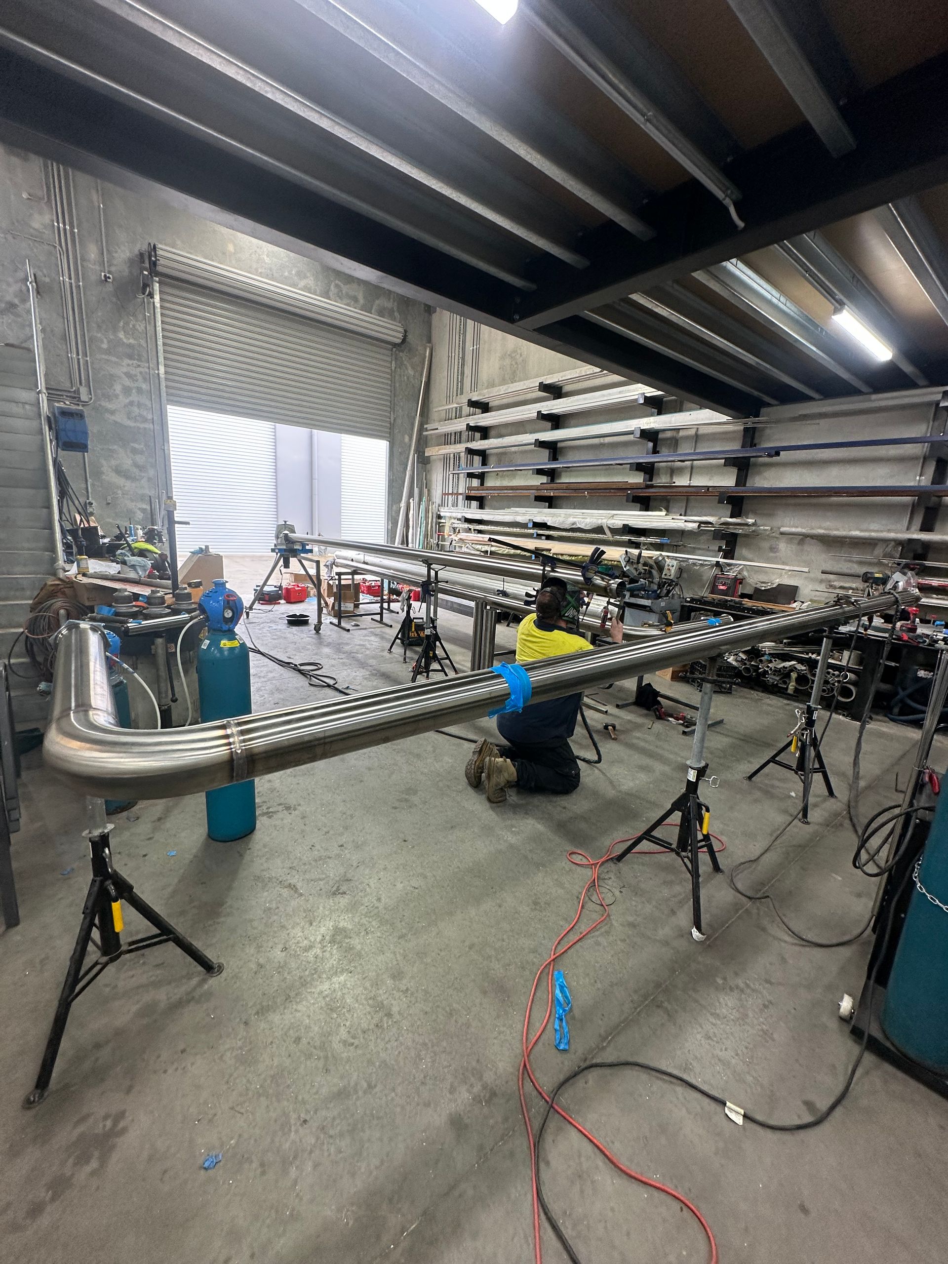 Indoor workshop with several bikes on stands and tools under bright lights — EB Metalworks in Somersby, NSW