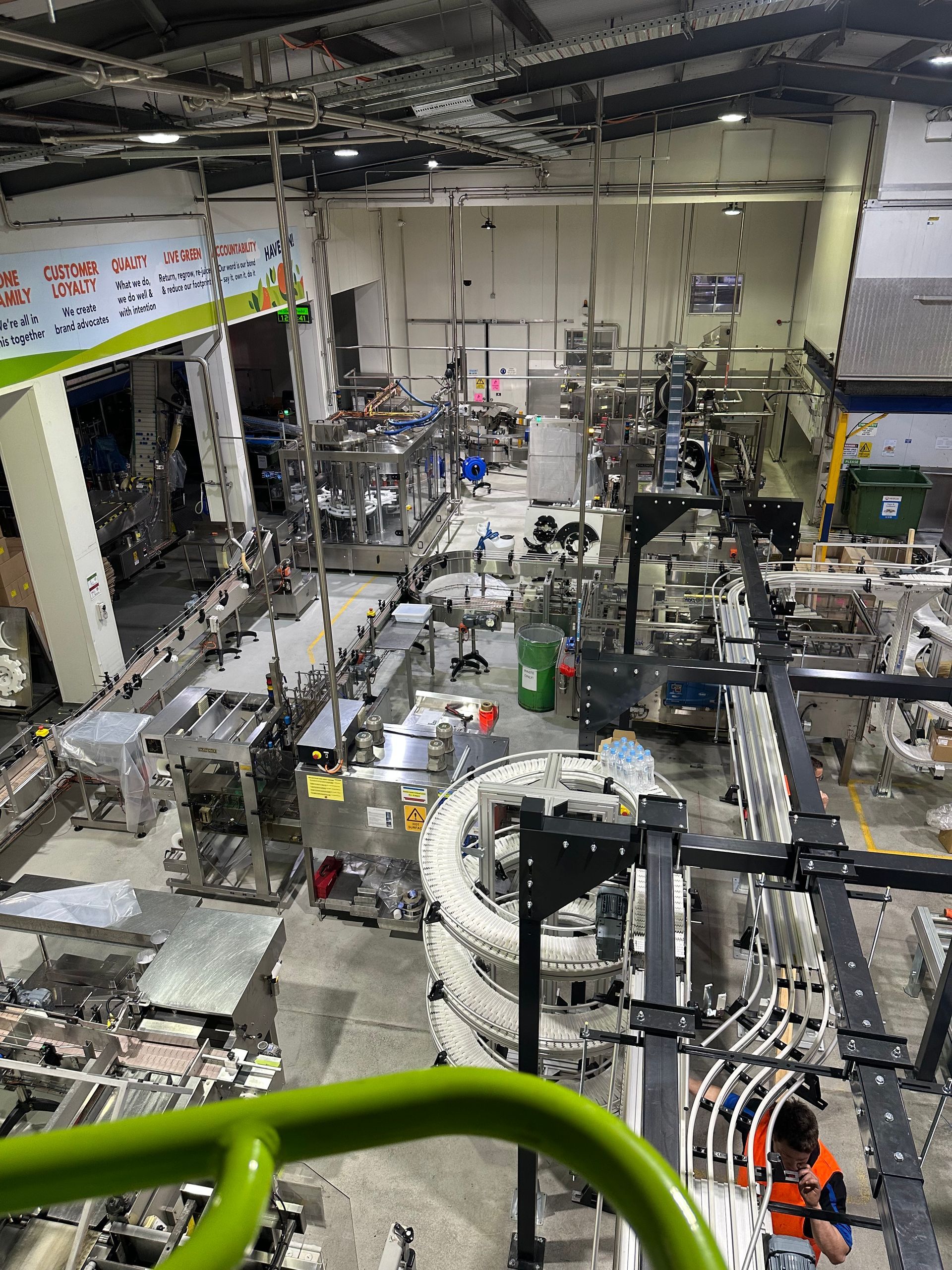 Large industrial workshop with machines, metal parts, and equipment under overhead lights — EB Metalworks in Somersby, NSW