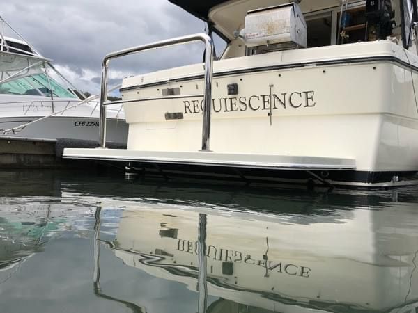 A Boat With the Name Requiescence on the Back is Docked in the Water — EB Metalworks in Somersby, NSW
