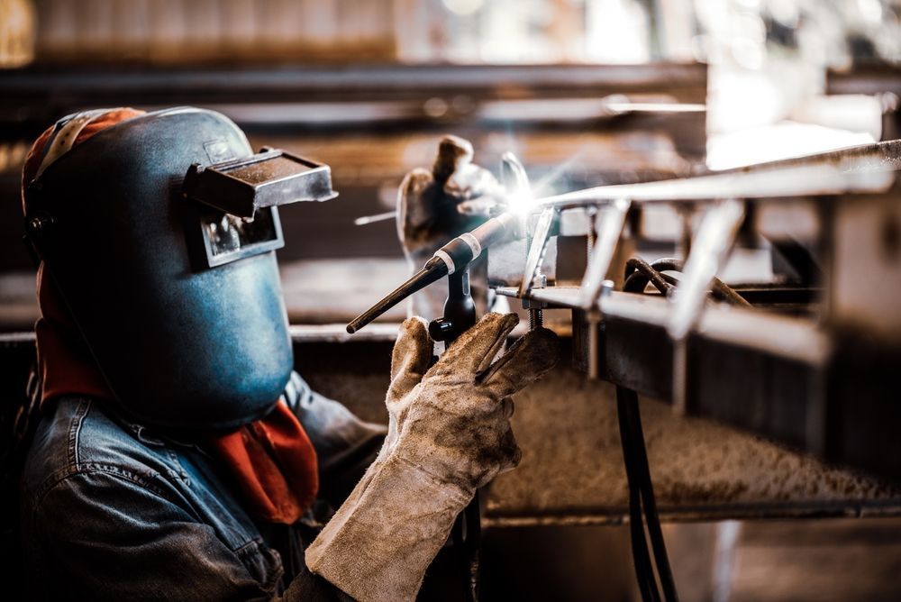 Welder Wearing a Mask and Gloves Welding Metal in a Workshop — EB Metalworks in Somersby, NSW