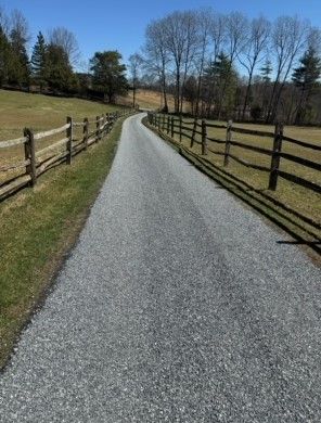 A yellow roller is rolling asphalt on a road.