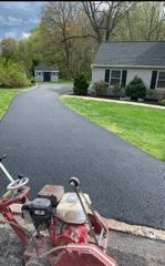 A machine is sitting on the side of a road in front of a house.