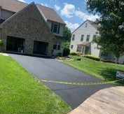 A man is spraying asphalt with a hose