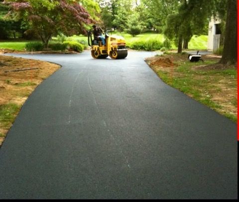 A man is driving a yellow roller down a road.
