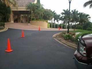 A truck is parked on the side of a road with orange cones on it.