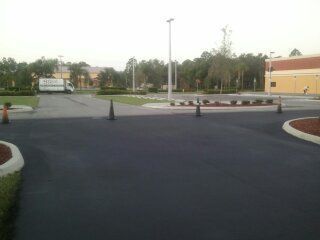 A truck is parked on the side of the road in a parking lot.
