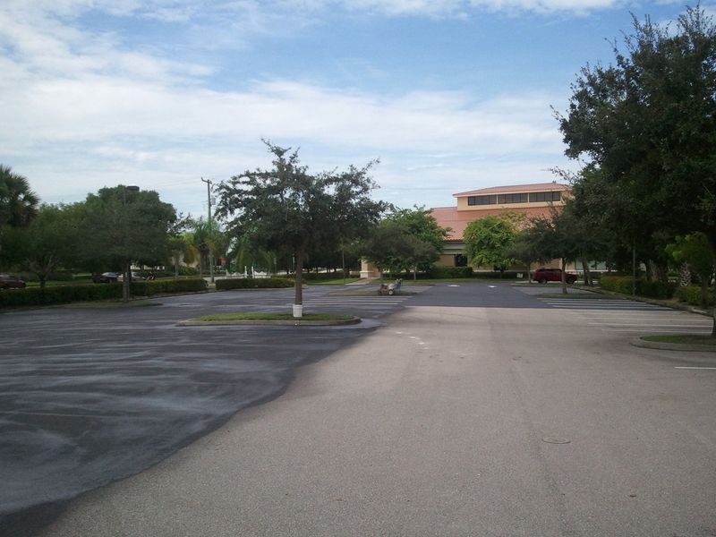 A parking lot with trees and a building in the background